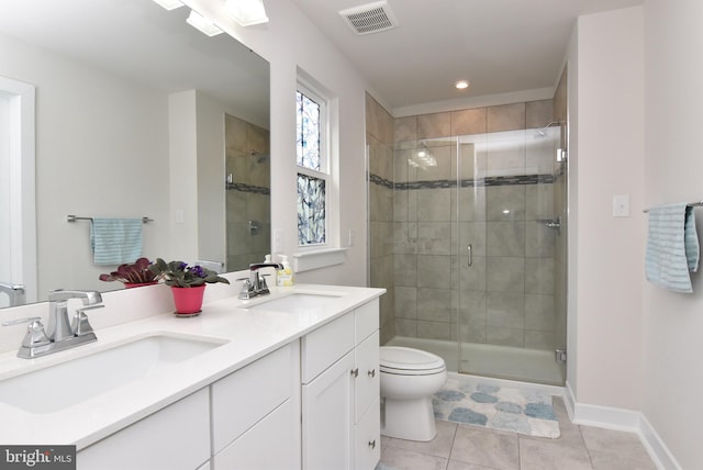 bathroom with a shower with door, vanity, toilet, and tile patterned flooring