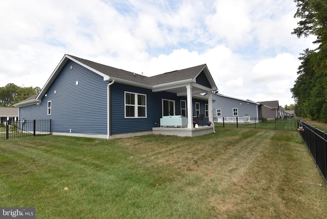 back of property with a patio area and a yard