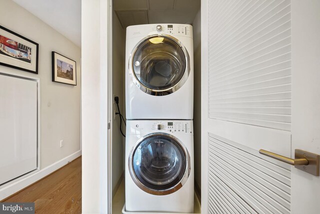 washroom featuring stacked washer / dryer and wood-type flooring