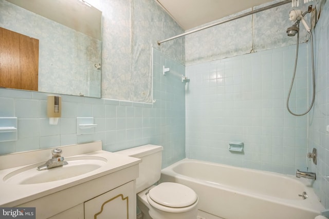 full bathroom with tile walls, tasteful backsplash, vanity, toilet, and tiled shower / bath