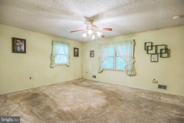 carpeted empty room featuring ceiling fan and a textured ceiling