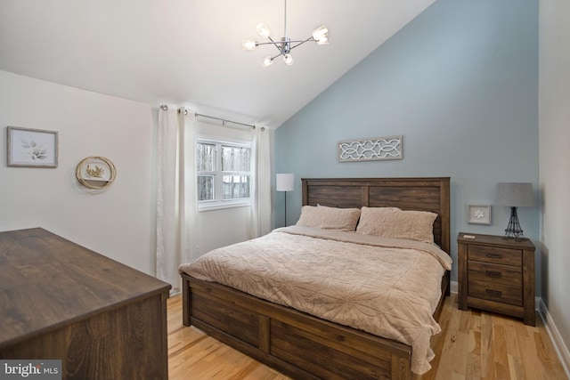 bedroom featuring vaulted ceiling, an inviting chandelier, and light hardwood / wood-style floors