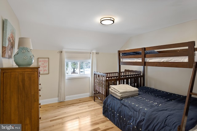 bedroom with wood-type flooring and lofted ceiling