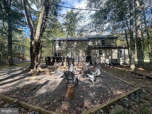 rear view of property with a deck and a fire pit