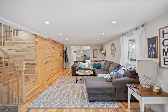 living room featuring hardwood / wood-style flooring, wood walls, and a barn door