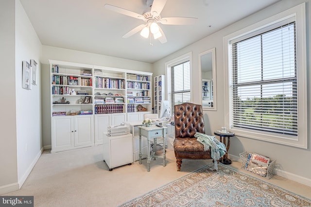 sitting room featuring baseboards, a ceiling fan, and carpet floors