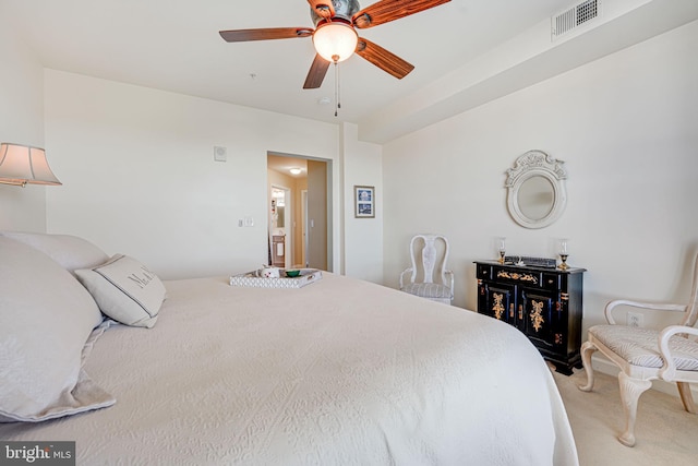 bedroom with light carpet, visible vents, and a ceiling fan