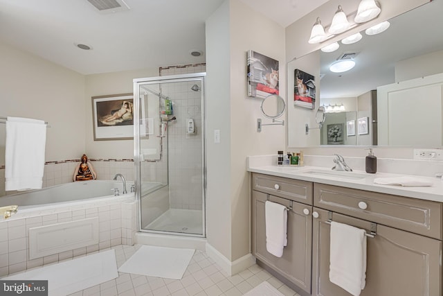 full bathroom featuring vanity, a shower stall, a garden tub, and tile patterned flooring