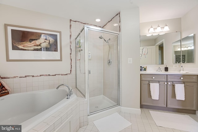 full bathroom with tile patterned floors, a stall shower, vanity, and a garden tub