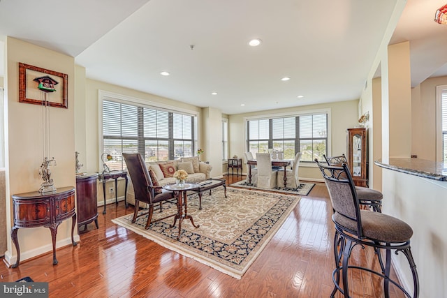 living area with recessed lighting, baseboards, and wood-type flooring