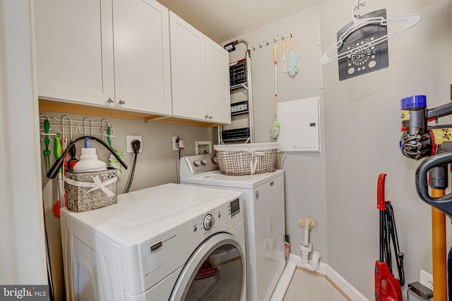 washroom with baseboards, cabinet space, and independent washer and dryer