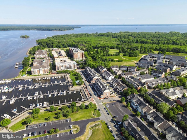 birds eye view of property featuring a water view and a wooded view