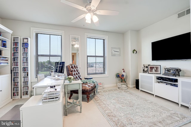 carpeted office space with visible vents, baseboards, and a ceiling fan