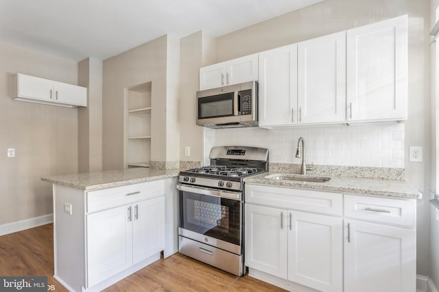 kitchen featuring white cabinetry, appliances with stainless steel finishes, kitchen peninsula, and sink