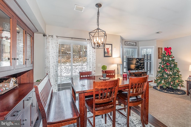 dining area with a chandelier and carpet floors