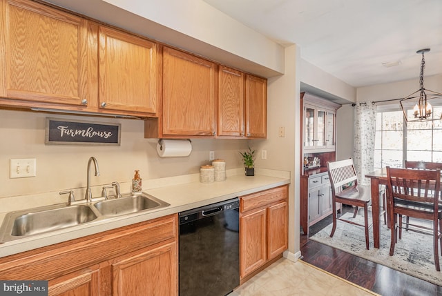 kitchen featuring sink, light wood-type flooring, black dishwasher, decorative light fixtures, and a chandelier