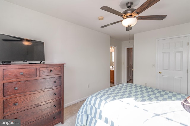 bedroom with light carpet, connected bathroom, and ceiling fan