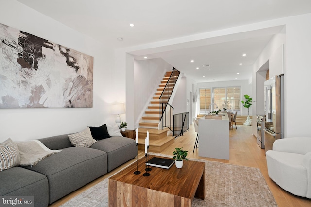 living room featuring light wood-type flooring and sink