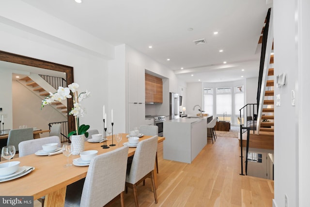 dining area with light wood-type flooring and sink