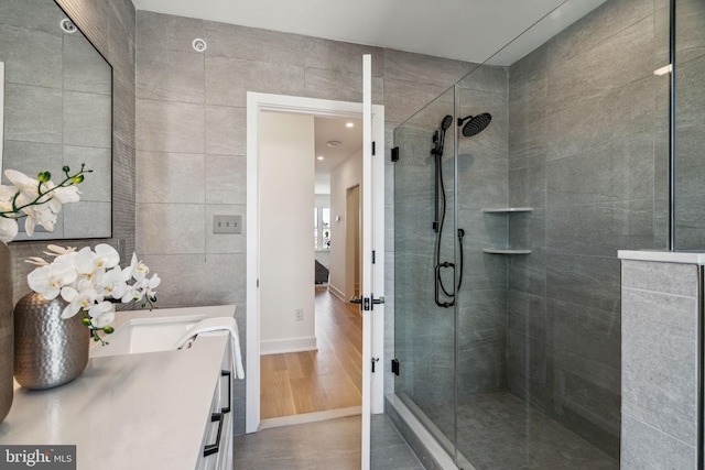 bathroom with vanity, a shower with shower door, and hardwood / wood-style floors