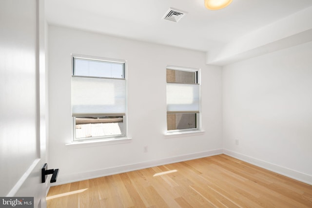 spare room with hardwood / wood-style floors and a healthy amount of sunlight