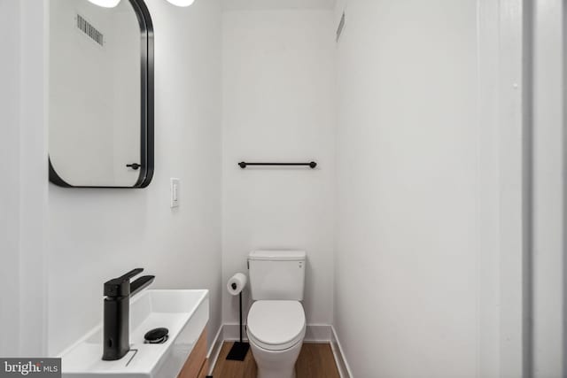 bathroom featuring hardwood / wood-style floors and toilet