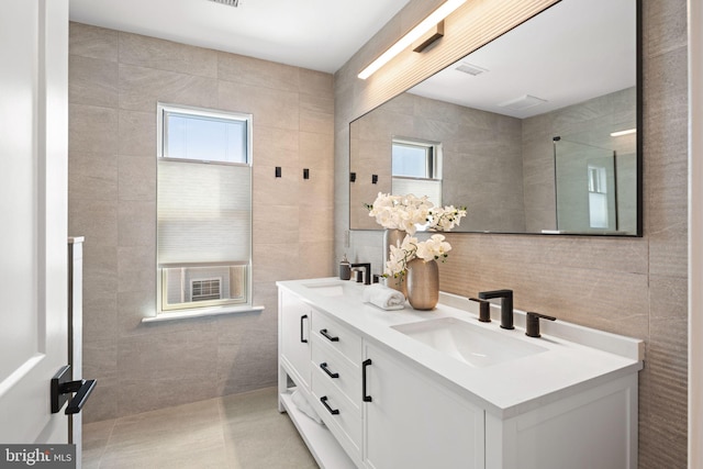 bathroom with tile walls, tile patterned floors, plenty of natural light, and vanity