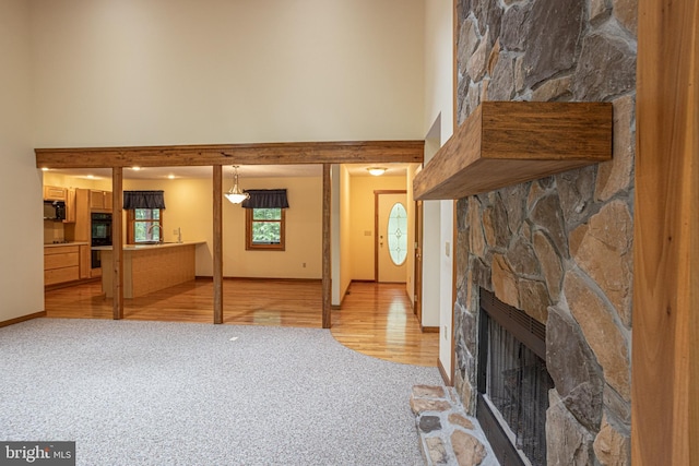 living room featuring a stone fireplace and light wood-type flooring