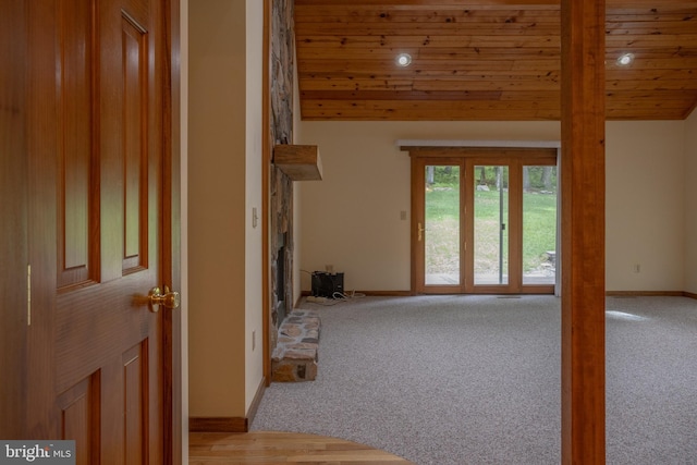 unfurnished living room with wood ceiling and light colored carpet