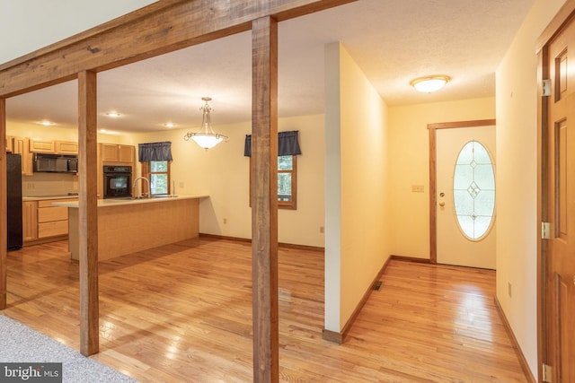 foyer featuring a textured ceiling, light hardwood / wood-style flooring, and sink