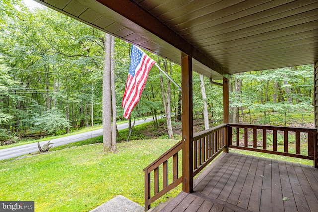 wooden terrace featuring a lawn