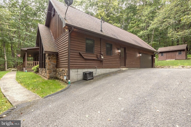 view of home's exterior with cooling unit, an outdoor structure, a garage, and a porch