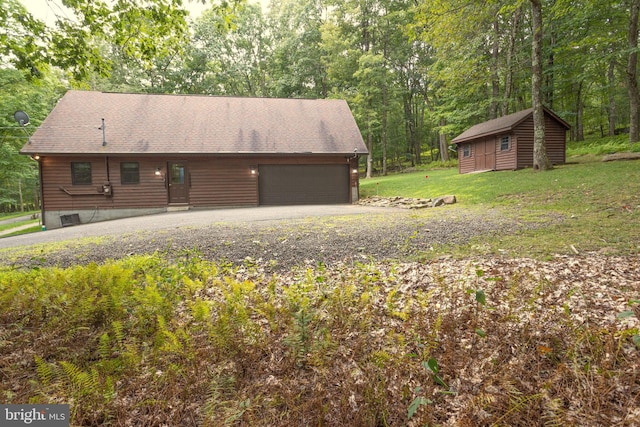 exterior space featuring an outdoor structure, a yard, and a garage