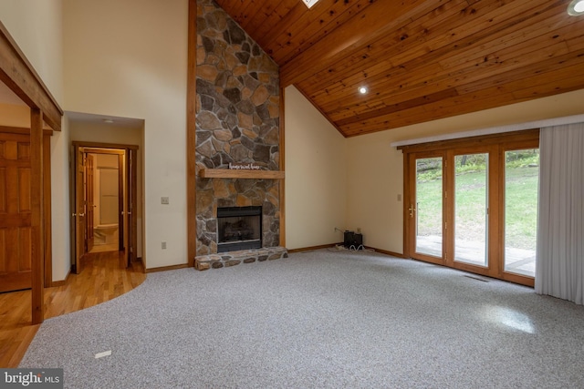 unfurnished living room with wood ceiling, a stone fireplace, high vaulted ceiling, and hardwood / wood-style flooring