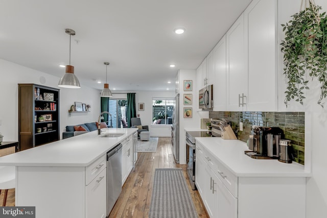 kitchen featuring white cabinetry, an island with sink, and stainless steel appliances