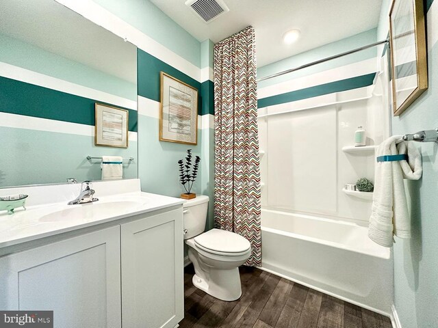 full bathroom featuring shower / bath combo with shower curtain, hardwood / wood-style floors, toilet, and vanity