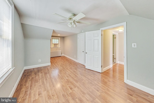 bonus room with radiator heating unit, light hardwood / wood-style floors, ceiling fan, and vaulted ceiling