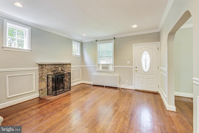 foyer with a healthy amount of sunlight, a fireplace, and radiator