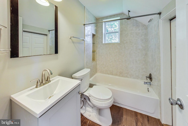 full bathroom featuring wood-type flooring, tiled shower / bath, vanity, and toilet