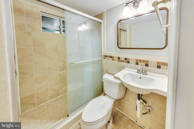 bathroom featuring tile walls, tile patterned flooring, toilet, and a shower with shower door