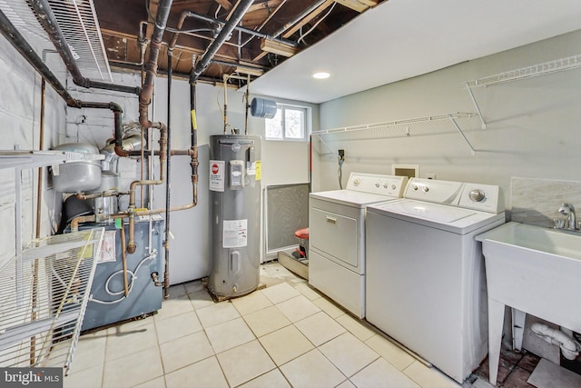 laundry room featuring light tile patterned floors, electric water heater, washer and dryer, and sink