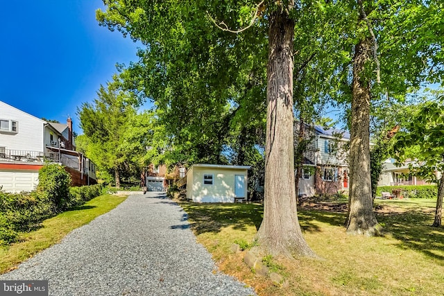 view of front of property featuring a shed and a front lawn