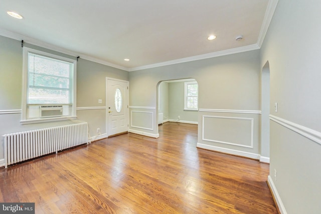 empty room with ornamental molding, radiator, hardwood / wood-style flooring, and cooling unit