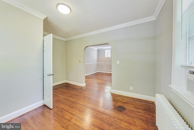 spare room with hardwood / wood-style flooring, ornamental molding, and radiator heating unit