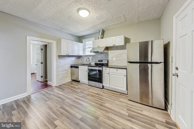 kitchen featuring a textured ceiling, white cabinetry, light hardwood / wood-style flooring, and stainless steel appliances