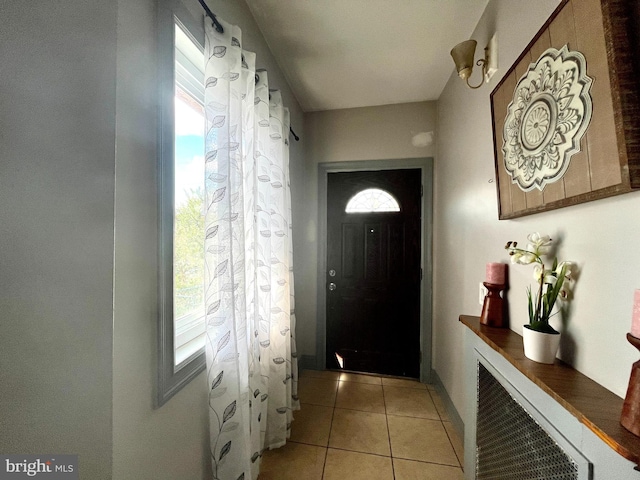 doorway to outside with light tile patterned flooring