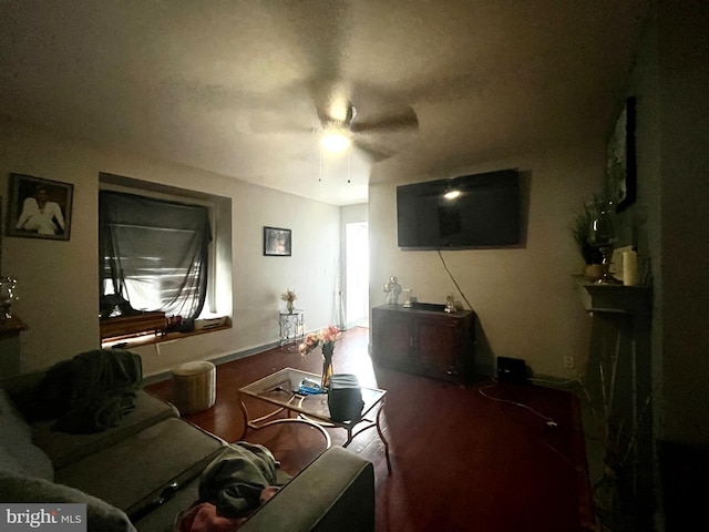 living area with a fireplace and a ceiling fan