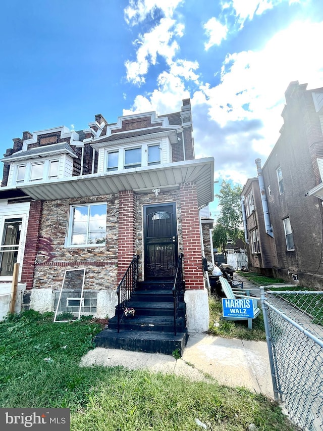 townhome / multi-family property featuring brick siding and fence