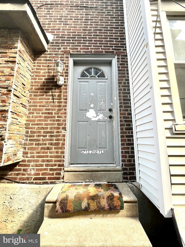 property entrance featuring brick siding