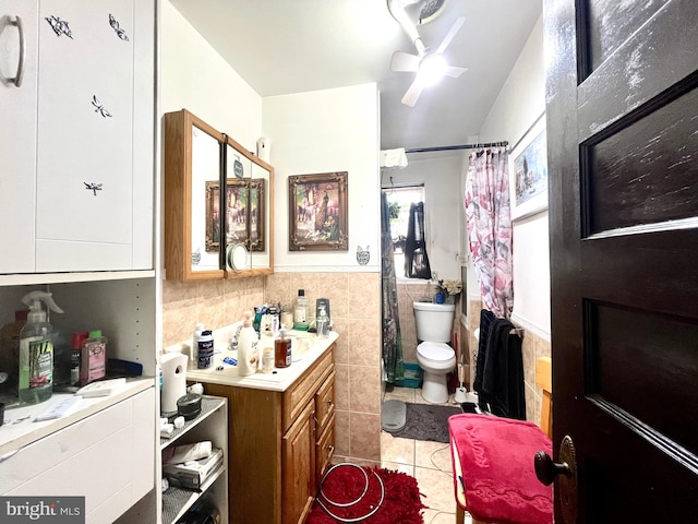 bathroom with tile walls, vanity, tile patterned flooring, ceiling fan, and toilet